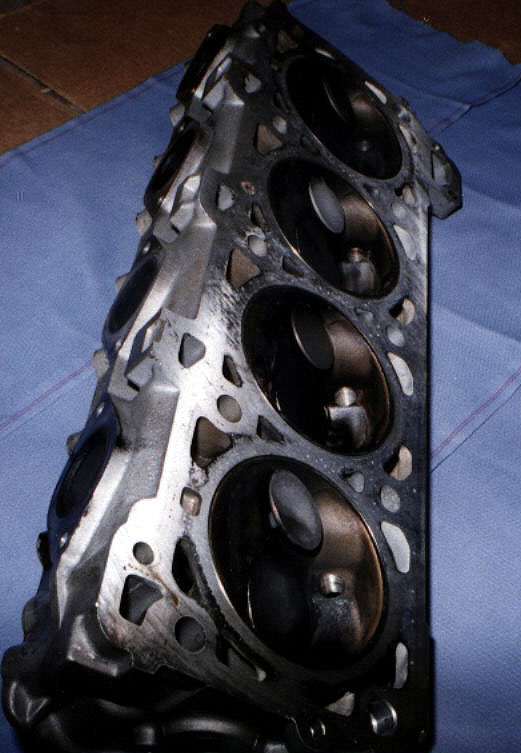 Side view of 944 Turbo cylinder head showing four bent exhaust valves after timing belt failure